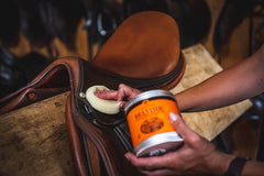 Carr & Day & Martin Belvoir Leather Balsam applied with cloth to condition leather tack and enhance shine.