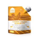 Open Farm chicken bone broth bottle pour shows clean ingredients for pet meals.