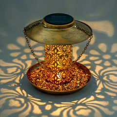 Ottsuls solar bird feeder lantern lit at dusk provides ambient garden light.
