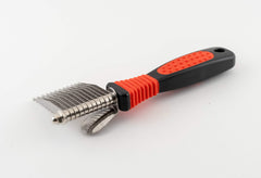 RYAN'S PET SUPPLIES Paw Brothers dematting tool with ergonomic handle shown during grooming session.