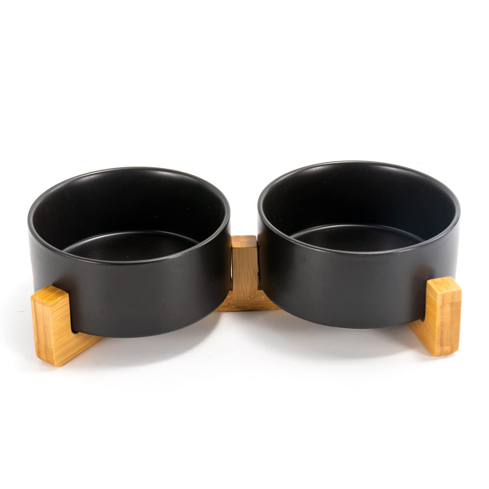 SPUNKYJUNKY ceramic dual-bowl set on wooden stand for mess-free meals.