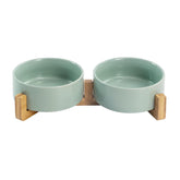 SPUNKYJUNKY ceramic bowls on wooden stand — front view for tidy feeding.