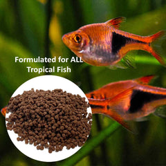 Vitalis Tropical Freshwater Pellets sinking slowly in an aquarium.