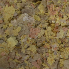 API Tropical Greens Flakes closeup shows textured flakes ideal for herbivorous tropical fish.
