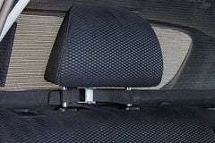Bushwhacker cargo barrier installation in a hatchback shows headrest attachment for quick, secure setup.