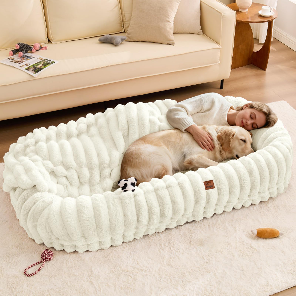 ChiXnuggle human dog bed cream side-pocket stores essentials during naps.