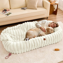 ChiXnuggle human dog bed cream side-pocket stores essentials during naps.