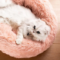Donut pet bed pink round with slip-resistant base for safety.