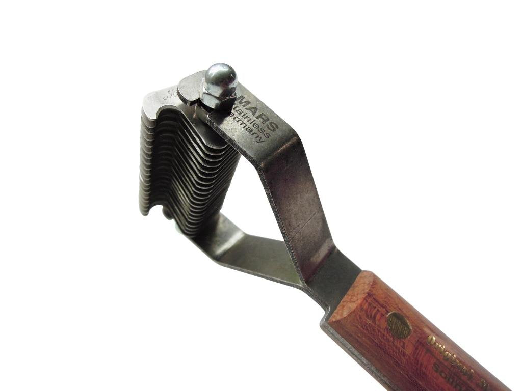 Mars Coat King grooming tool in action on a pet coat reducing matting while easing brushing