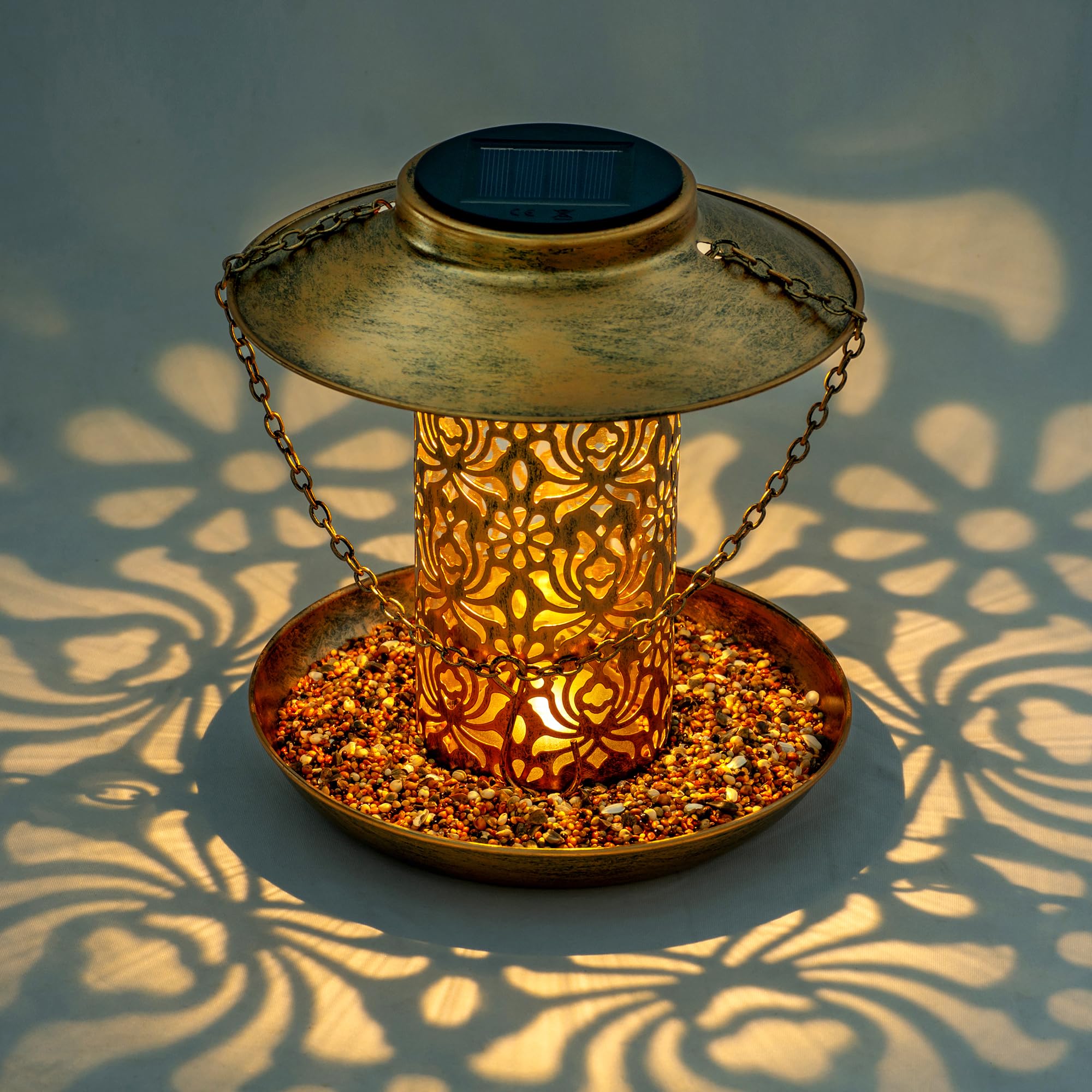 Ottsuls solar bird feeder lantern lit at dusk provides ambient garden light.