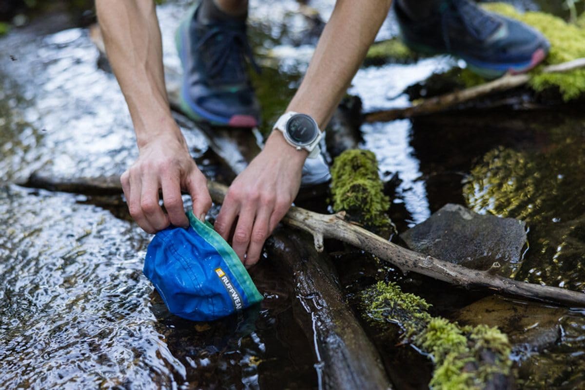Ruffwear Trail Runner bowl beside dirt and drool, proving rugged durability.