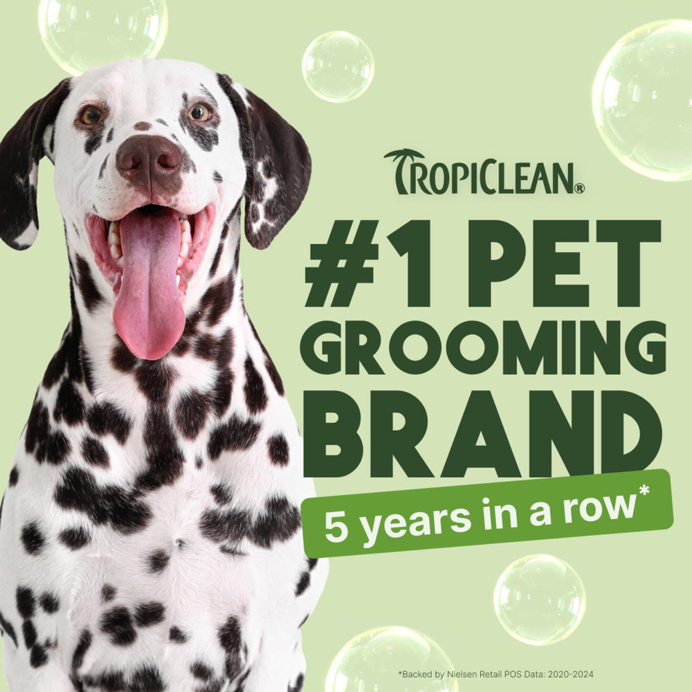 TropiClean deodorizing dog shampoo with aloe coconut scent shown beside a clean coat.