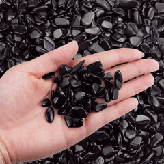 Twdrer black obsidian chips in fish tank as decorative substrate reducing splash.