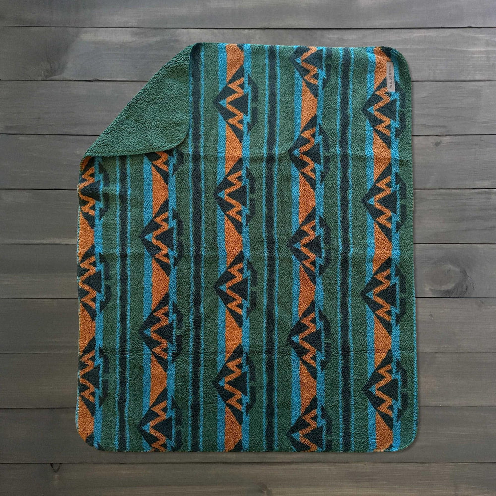 Wilderdog olive blanket outdoors on grass for campsite or car trips.